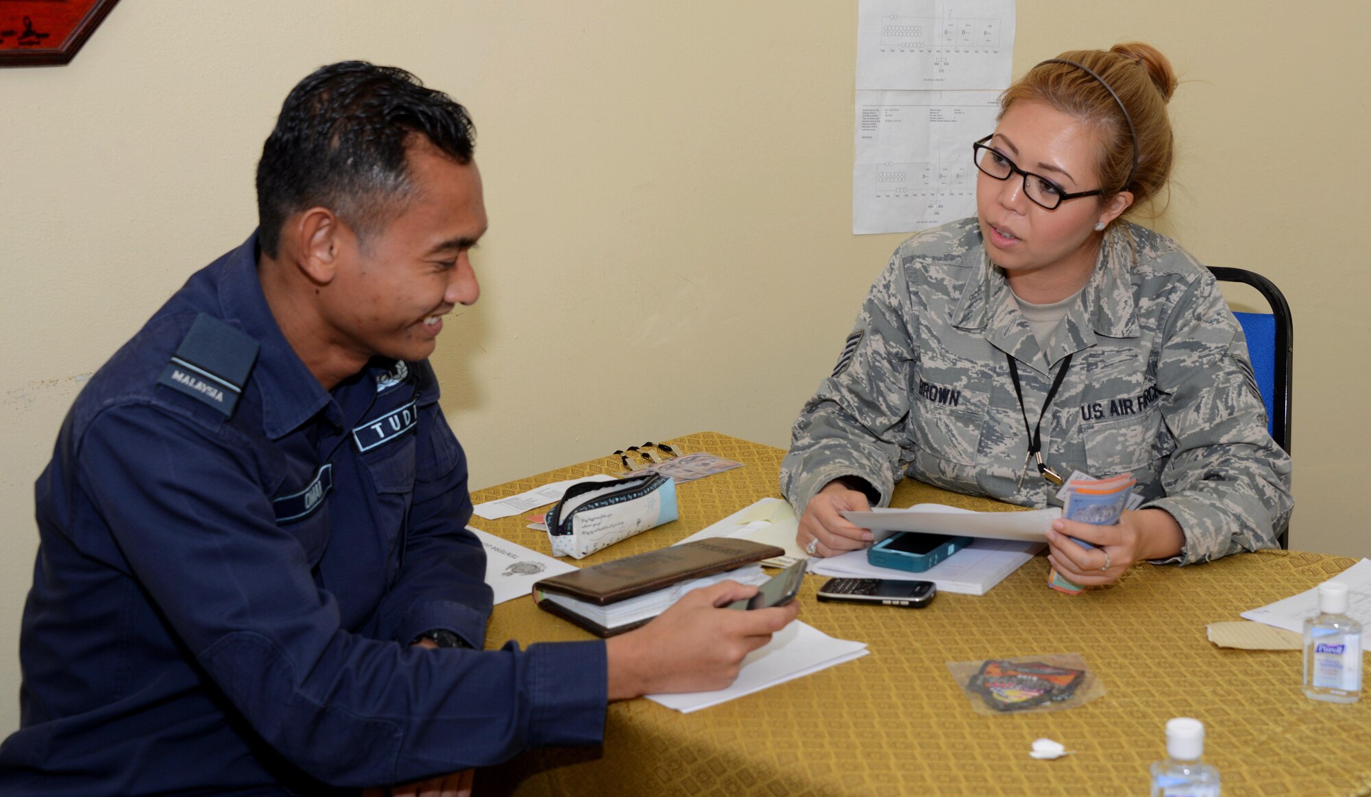From left, Royal Malaysian Air Force, Lt. Mohd Al Omar Bin Che Abu Baker, and U.S. Air Force Tech. Sgt. Karla Brown, 353rd Special Operations Maintenance Squadron,  work together to coordinate logistics May 30, 2015 at Subang Air Base, Malaysia. The 353rd Special Operations Group, from Kadena Air Base, Japan, along with the 36th Airlift Squadron, from Yokota Air Base, Japan, are participating in Joint Chiefs of Staff Exercise Teak Mint with the Royal Malaysian Air Force, a multinational and bilateral training used to enhance capabilities and capacities between the two countries. (U.S. Air Force photo by Tech. Sgt. Kristine Dreyer)