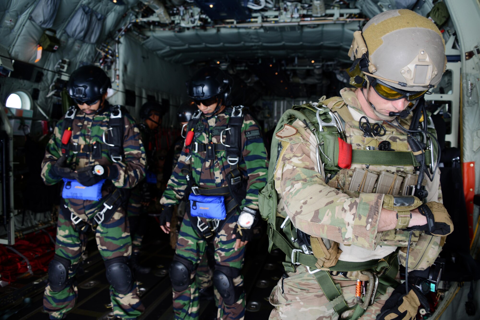 On right, a pararescueman with the 320th Special Tactics Squadron checks his altimeter as his Malaysian counterparts wait to jump out of an MC-130J Commando II from the 17th Special Operations Squadron near Kuantan, Malaysia, June 8, 2015.  The High-Altitude Low-Opening jumps were conducted as part of Exercise Teak Mint, a multinational and bilateral exercise between the Royal Malaysian Air Force and the U.S. Air Force.  (U.S. Air Force photo by Tech. Sgt. Kristine Dreyer)  