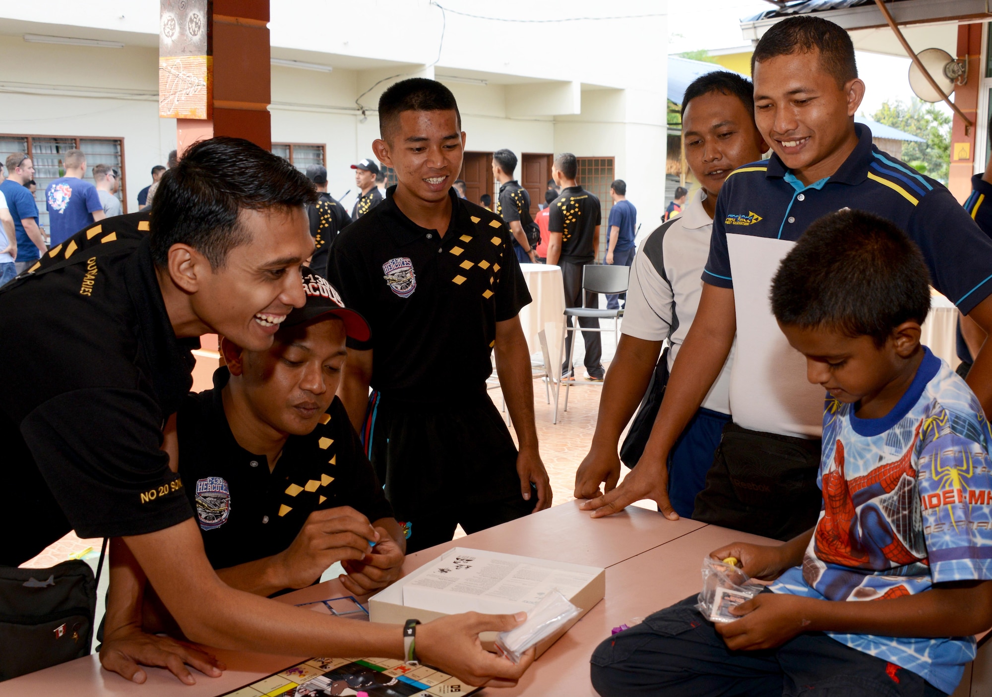 Members from the Royal Malaysian Air Force play a game with a child from the Rumah Kasih Hormoni Orphanage near Kuala Lumpur, Malayasia, June 6, 2015.  As part of Exercise Teak Mint, members from the RMAF, U.S. Air Force came together to help with repairs around the orphanage.  Members from the 353rd Special Operations Group donated more than  $1,000 in clothes, games and sports equipment.   (U.S. Air Force Tech. Sgt. Kristine Dreyer)