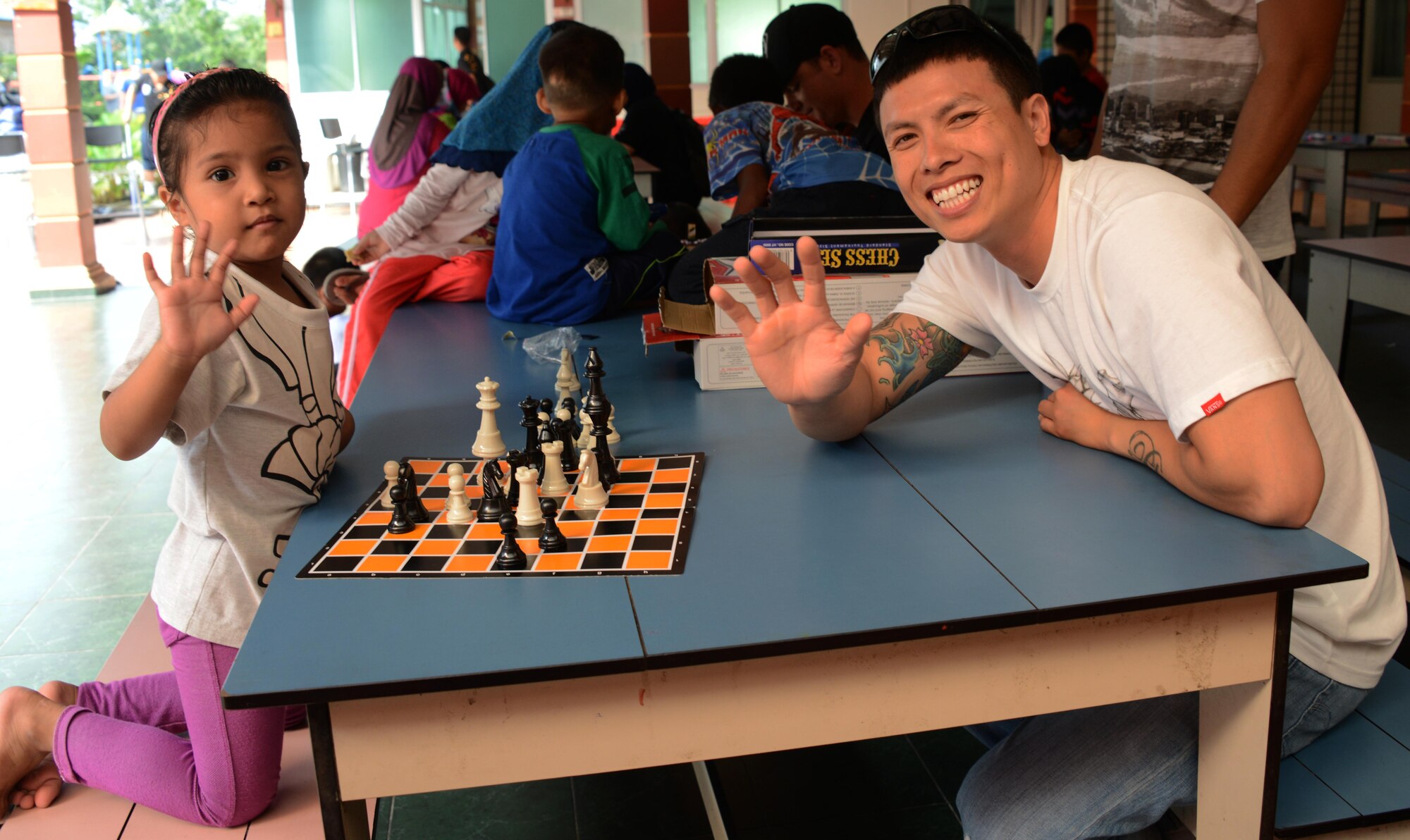 U.S. Air Force Staff Sgt. Tan Pham, 353rd Special Operations Maintenance Squadron, integrated instrument and flight control systems craftsman, plays chess with a young girl from the Rumah Kasih Hormoni Orphanage near Kuala Lumpur, Malaysia, June 6, 2015.  As part of Exercise Teak Mint, members from the RMAF, U.S. Air Force came together to help with repairs around the orphanage and donated more than $1,000 in clothes, games and sports equipment.  (U.S. Air Force photo by Tech. Sgt. Kristine Dreyer)
