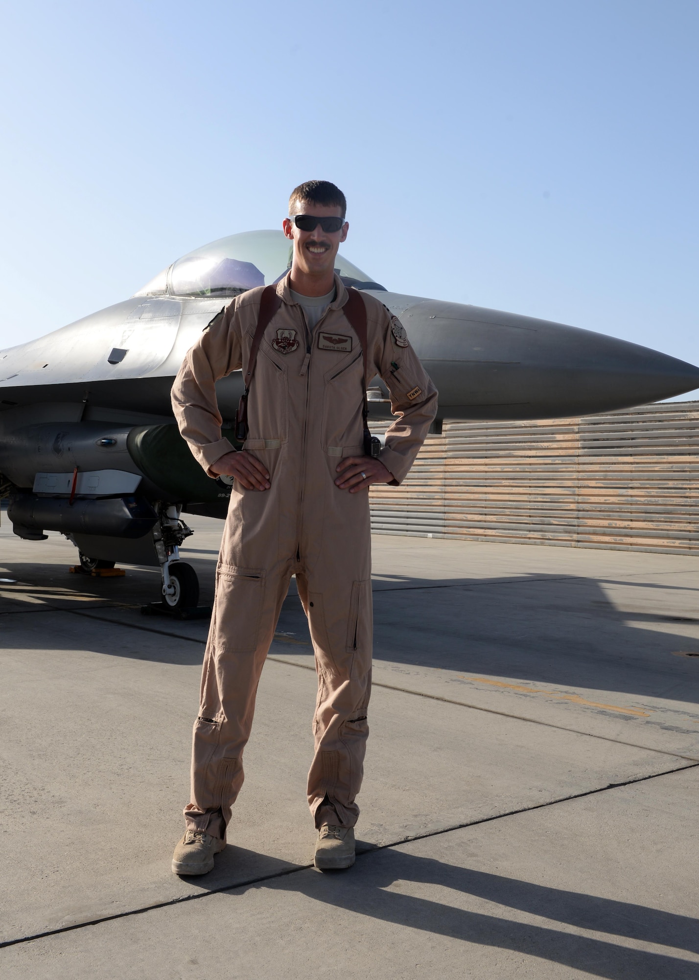 U.S. Air Force Capt. Dakota Olsen, 555th Expeditionary Fighter Squadron F-16 Fighting Falcon pilot, poses in front of a jet June 17, 2015, at Bagram Airfield, Afghanistan. Olsen’s job is to provide close air support and armed over watch for military personnel in Afghanistan. He flies various sorties and missions throughout the country on a daily basis providing airpower to ensure a safe and secure environment for personnel at BAF. (U.S. Air Force photo by Senior Airman Cierra Presentado/Released)