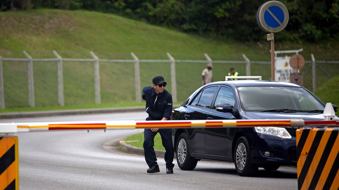 Ken Asato, a corporal with the Uruma City Police Department, exits his vehicle as an “intruder” on Camp Courtney, Okinawa, Japan, June 11, 2015 during bilateral training between service members and the UCPD. The training ensured the camp guard, and the Provost Marshal’s Office are proficient in communicating with the UCPD to mitigate security threats involving service members and Okinawa residents. During the training event, Asato posed as an Okinawa resident entering the base without authorization. Camp guard Marines patrolling the perimeter of the base apprehended the intruder and rehearsed turnover procedures with PMO Marines.