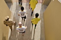 Players exit the locker room tunnel towards the soccer field to being the soccer match between deployed U.S. and Qatari military members in celebration of the 240th U.S.  Army birthday June 14, 2015 at Al Udeid Air Base, Qatar. AUAB All-Stars planned a soccer match to help strengthen the partnership between the U.S. and Qatari military and build friendships between service members. (U.S. Air Force photo/Staff Sgt. Alexandre Montes)