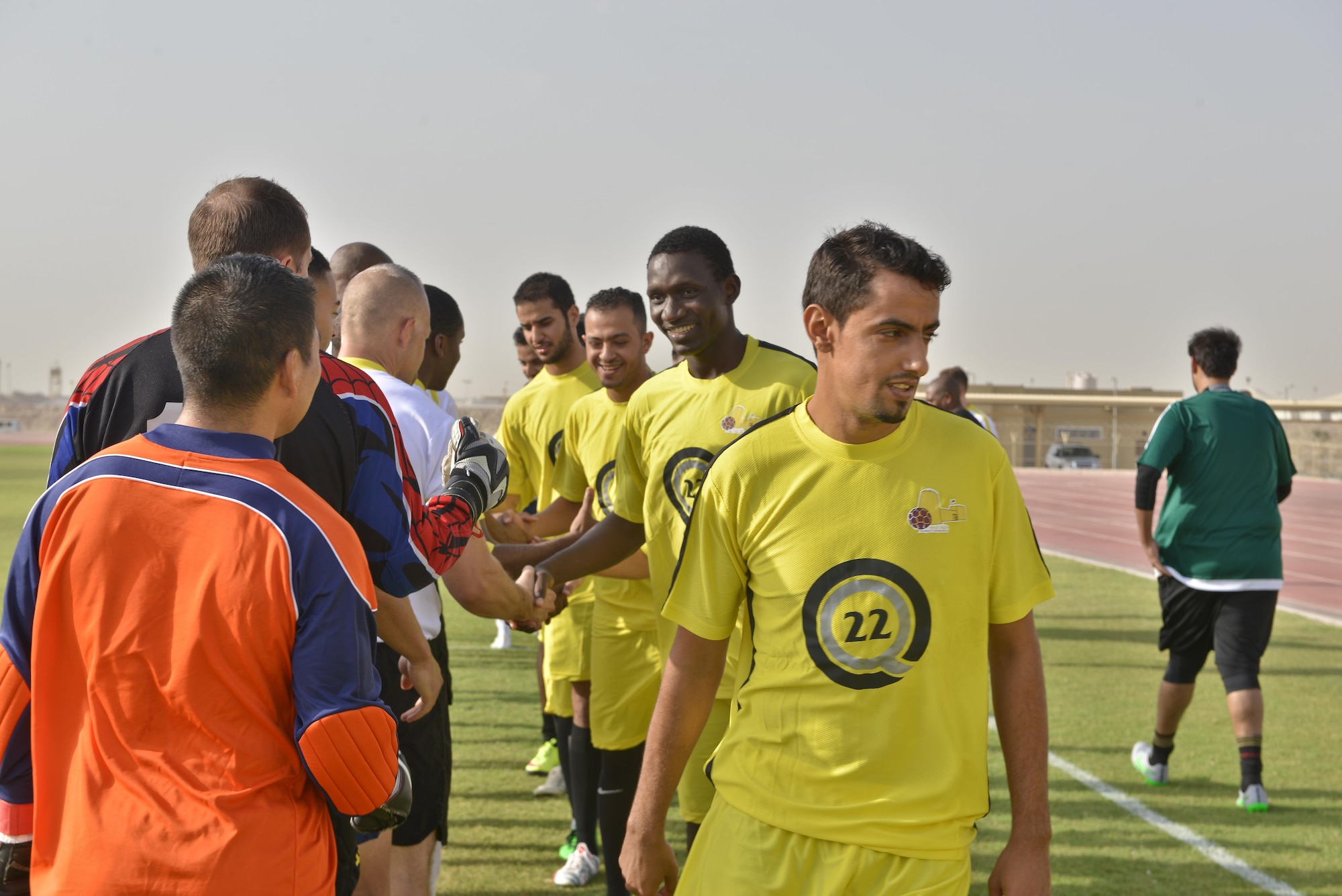 Deployed U.S. and Qatari military members shake hands prior to the start of a soccer match in celebration of the 240th U.S.  Army birthday June 14, 2015 at Al Udeid Air Base, Qatar. AUAB All-Stars planned a soccer match to help strengthen the partnership between the U.S. and Qatari military and build friendships between service members. (U.S. Air Force photo/Staff Sgt. Alexandre Montes)