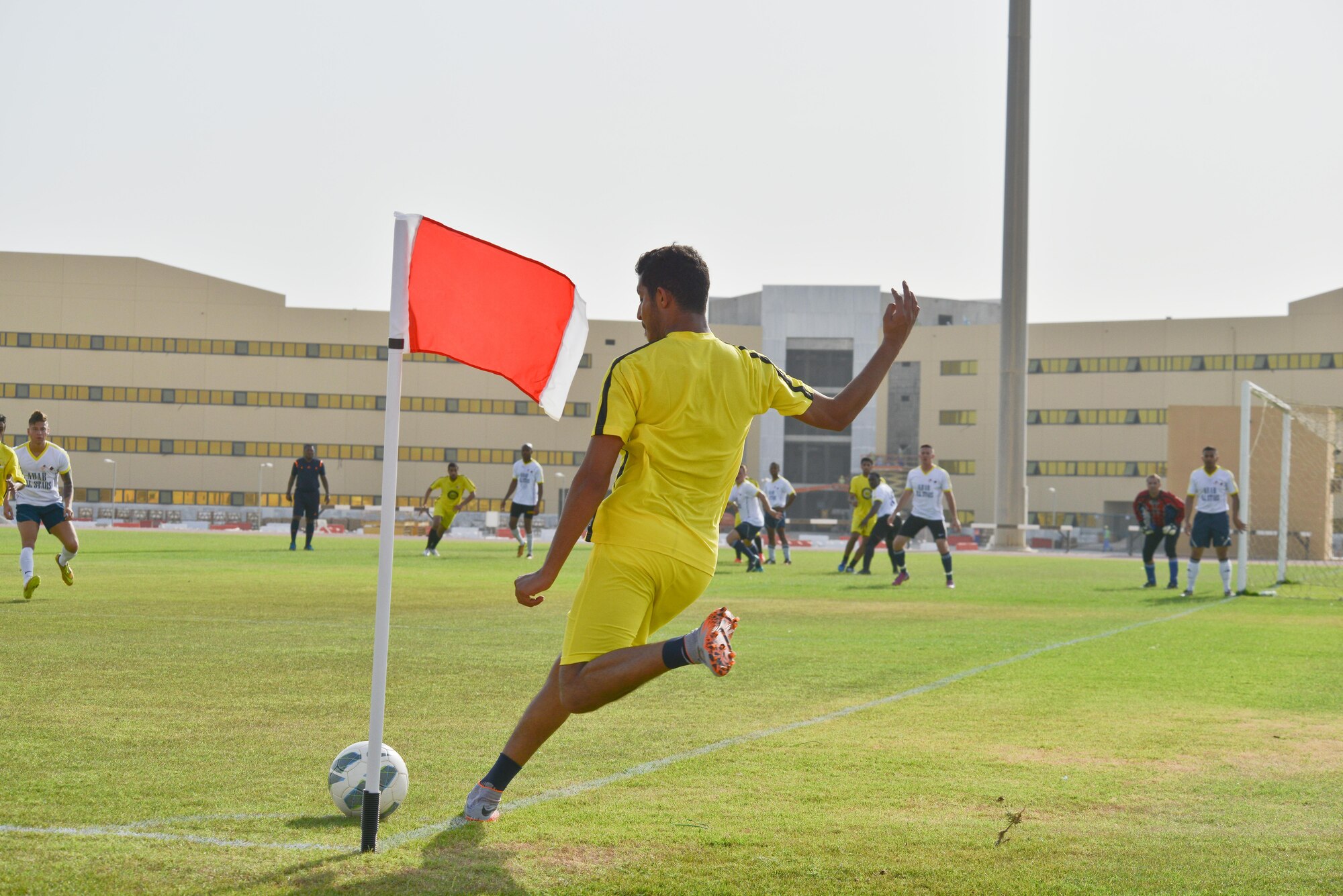 A member of the Qatari Air Base soccer team launches a corner kick towards the goal in a match against the Al Udeid All-Stars in celebration of the 240th U.S.  Army birthday June 14, 2015 at Al Udeid Air Base, Qatar. AUAB All-Stars planned a soccer match to help strengthen the partnership between the U.S. and Qatari military and build friendships between service members. (U.S. Air Force photo/Staff Sgt. Alexandre Montes)