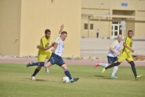 A U.S. Air Force member of the Al Udeid All-Stars kicks towards the goal of the Qatari Air Base soccer team during a soccer match between deployed U.S. and Qatari military members in celebration of the 240th U.S.  Army birthday June 14, 2015 at Al Udeid Air Base, Qatar. AUAB All-Stars planned a soccer match to help strengthen the partnership between the U.S. and Qatari military and build friendships between service members. (U.S. Air Force photo/Staff Sgt. Alexandre Montes)