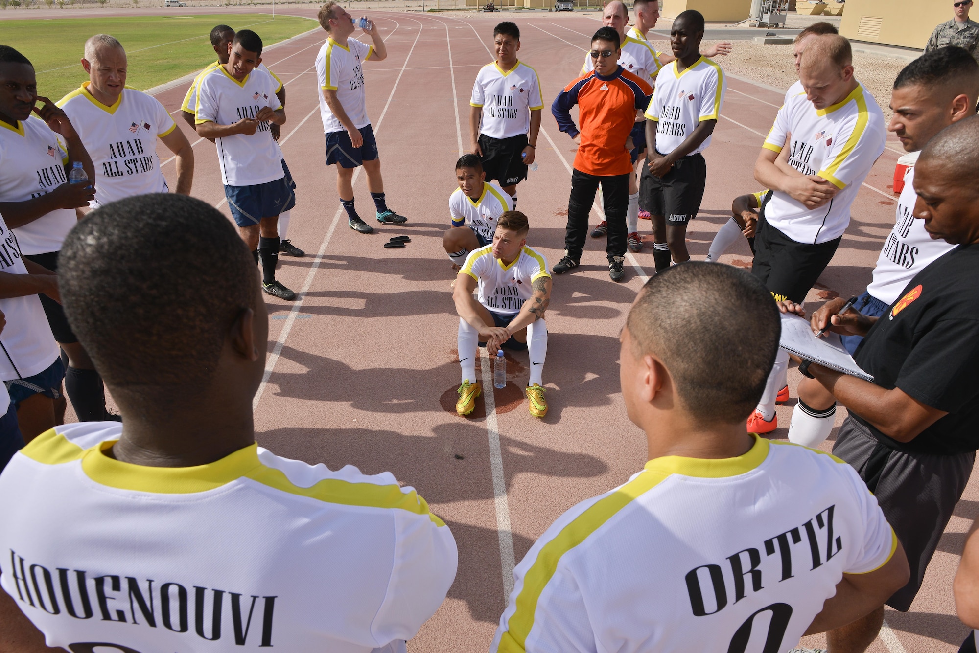 Members of the Al Udeid All-Stars go over a game plan at half-time during a soccer match against Qatari military members in celebration of the 240th U.S.  Army birthday June 14, 2015 at Al Udeid Air Base, Qatar. AUAB All-Stars planned a soccer match to help strengthen the partnership between the U.S. and Qatari military and build friendships between service members. (U.S. Air Force photo/Staff Sgt. Alexandre Montes)