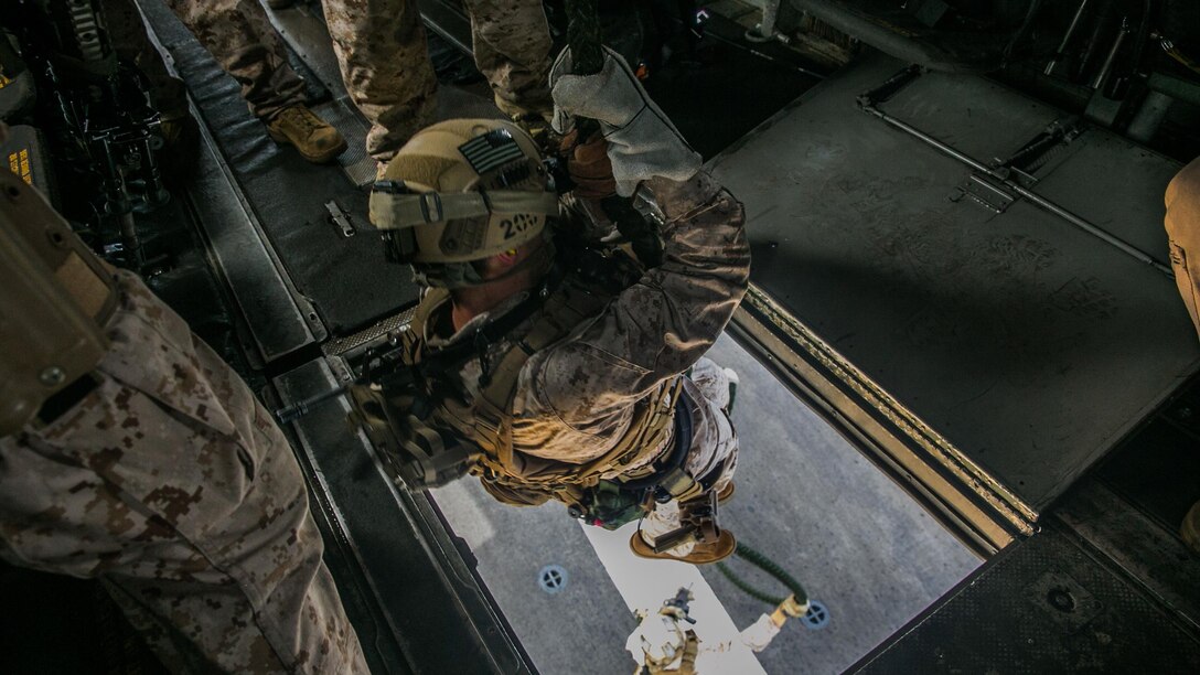 A U.S. Marine with the 15th Marine Expeditionary Unit’s Maritime Raid Force fast-ropes out of a CH-53E Super Stallion onto the flight deck of the USS Essex (LHD 2) at sea in the Indian Ocean, June 17, 2015. Fast-roping gives these Marines the capability of a rapid insert from different types of aircraft onto both land and moving vessels. 