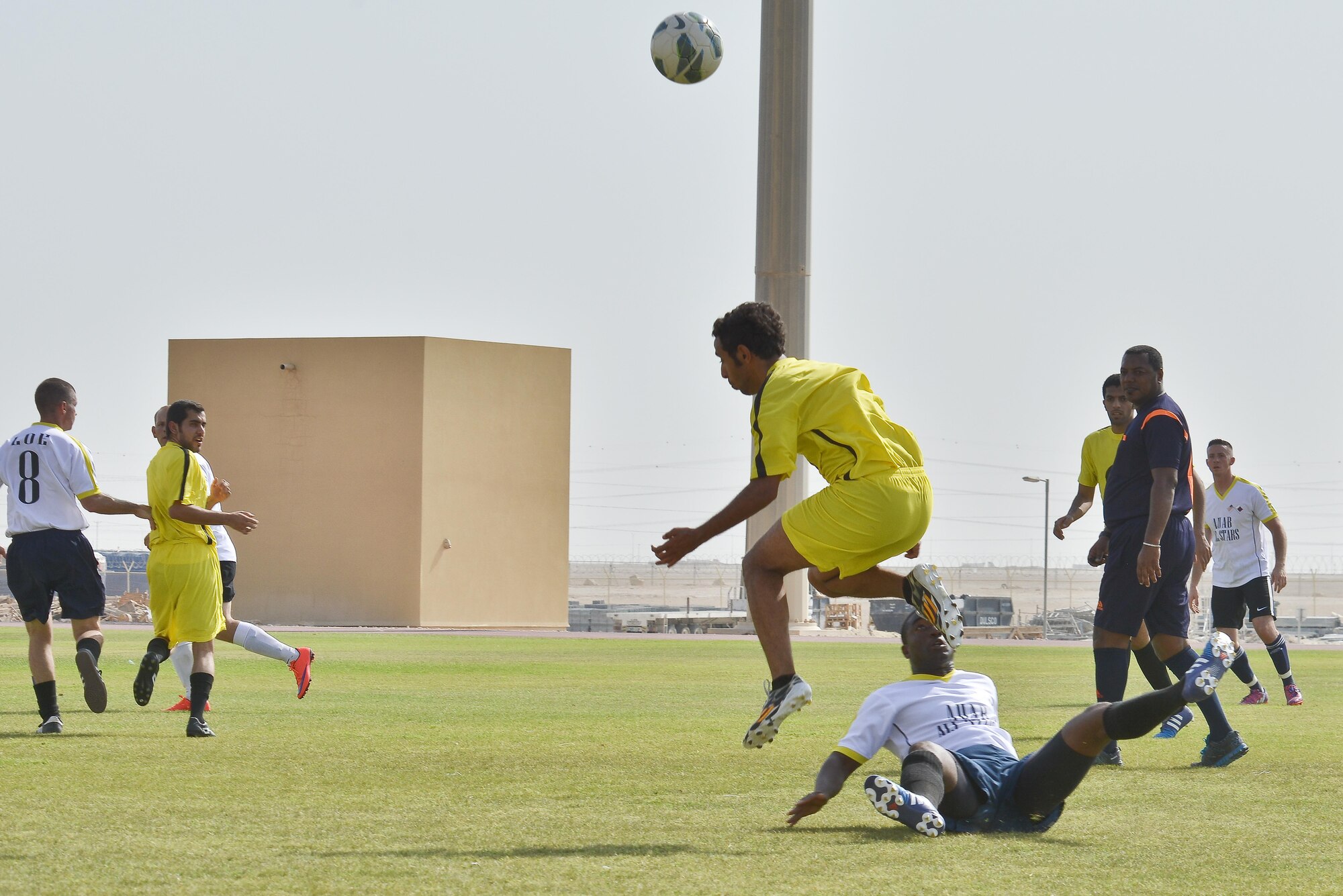 A member of the Qatari Air Base soccer team heads the ball towards a teammate in a match against the Al Udeid All-Stars in celebration of the 240th U.S.  Army birthday June 14, 2015 at Al Udeid Air Base, Qatar. AUAB All-Stars planned a soccer match to help strengthen the partnership between the U.S. and Qatari military and build friendships between service members. (U.S. Air Force photo/Staff Sgt. Alexandre Montes)