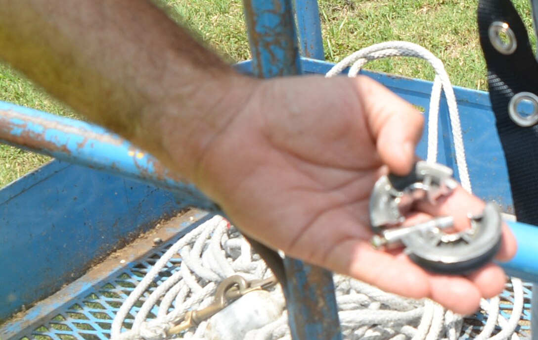 A broken pulley mechanism is removed from the flag pole in front of Marine Corps Logistics Base Albany’s Coffman Hall, June 17.