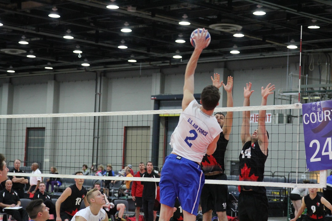 Air Force 2nd lt. Anthony Emtman of Dover AFB, Del. delivers a high spike over Team Canada during the 2015 Armed Forces Volleyball Championship held in conjunction with the USA Volleyball National Championship at the COBO Center in Detroit, Mich. 22-24.