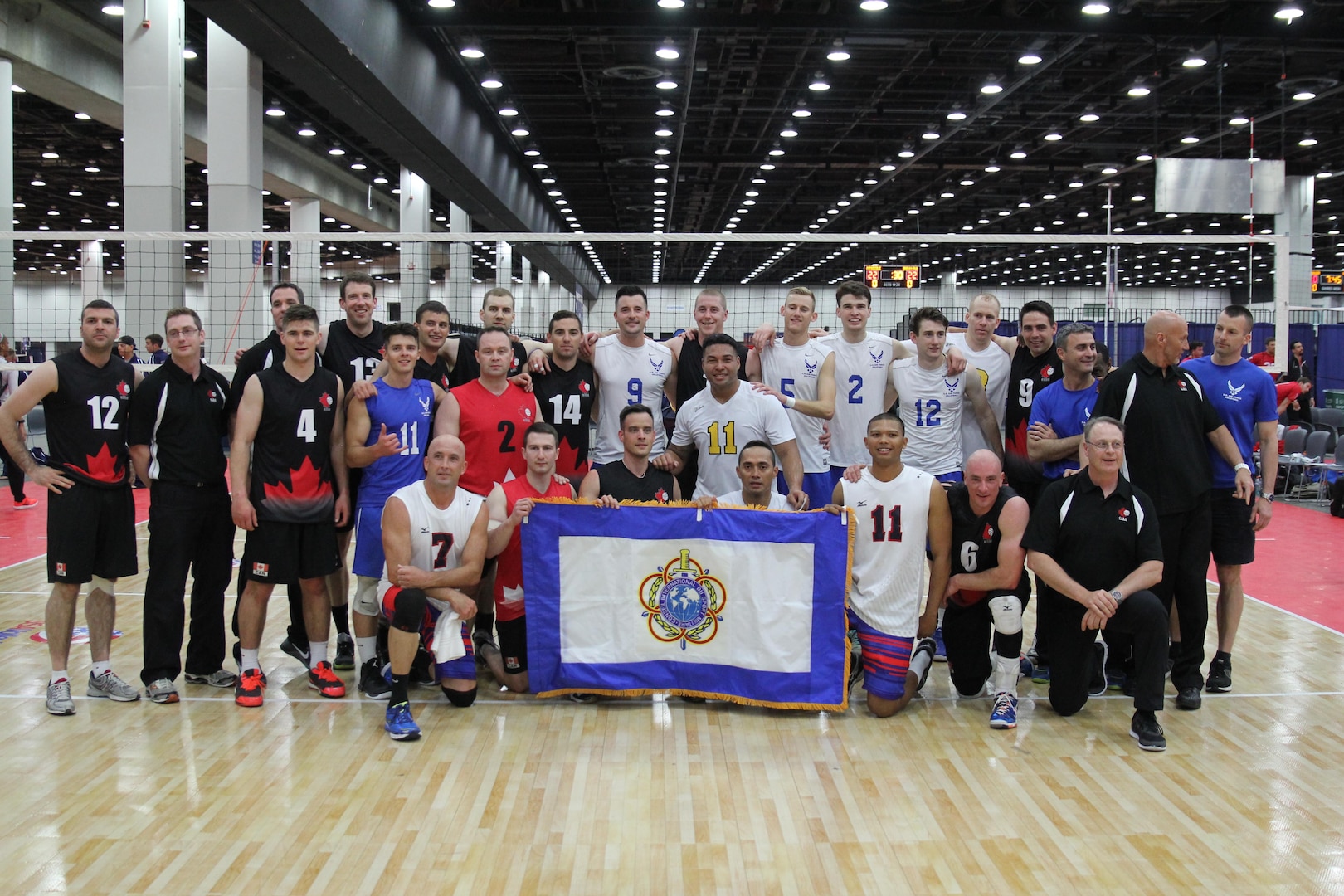 Service members from the Army, Navy and Air Force men's volleyball teams pose with Team Canada after a friendly international Conseil International du Sport Militaire (CISM) exhibition match during the 2015 Armed Forces Volleyball Championship held in conjunction with the USA Volleyball National Championship at the COBO Center in Detroit, Mich. 22-24.