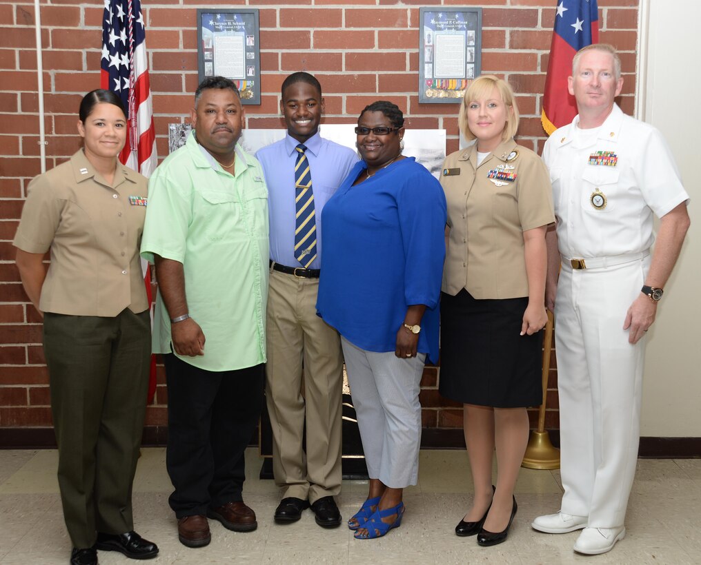 Jawaun Stanley, a Lee County High School graduate, (center) stands with Capt. Rene Barber, project manager, Marine Corps Systems Command-Albany (left); his dad, Kevin Stanley (second from left); his mom, Candita Stanley (third from right); Petty Officer 2nd Class Nina Hughes, Navy recruiter (second from right); and Leading Chief Petty Officer Brett Yahn, Navy Recruiting Station Albany, Ga., (right). The 18-year-old enlisted as a midshipman in the Navy Reserves.