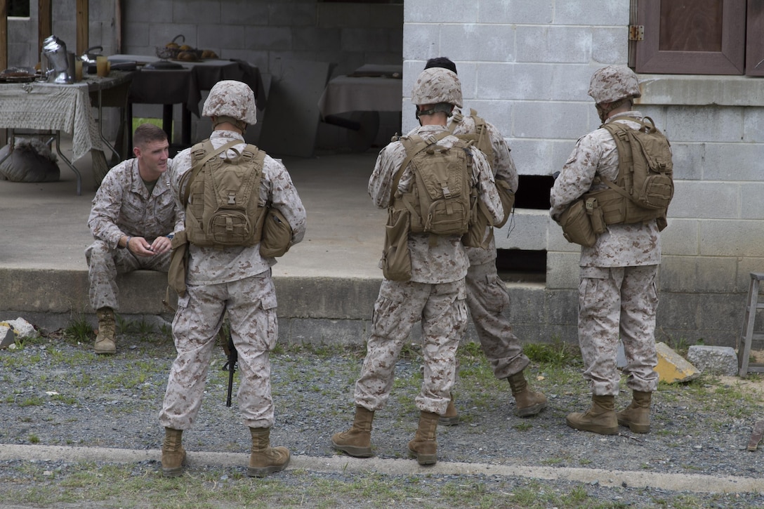 Marines from Company B take a break between training evolutions at Marine Corps Base Quantico’s military operations in urban terrain, training facility. On June 17, 2015 more than 100 Marines from B Co., Marine Barracks Washington, D.C., traveled to the Quantico, Va. MOUT town to refine their individual actions in an urban environment. “The training is focused on 1000-level training and readiness tasks [to include] making lower level entry into a compound and room clearing using proper techniques and procedures,” said Capt. David Moon, 3rd platoon commander, B. Co, Marine Barracks Washington, D.C. “With the complexity of today’s operating environment and the growth in large urban hubs this is the focus for the future. Although there is still importance on conventional warfare, a lot of the wars are fought in the urban environment.” (U.S. Marine Corps photo by Cpl. Skye Davis/Released)