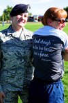 Staff Sgt. Robin Hopkins proudly displays a T-shirt she was given, which states, “And though she be but little, she is fierce,” on June 7, 2015. Master Sgt. Kimberly Ice, a fellow member of the Security Forces Squadron, is all smiles with the accomplishment of Hopkins' performance during her physical training test. Hopkins, a member of the Bernalillo County Sheriff Department, was injured in the line of duty and was shot in the leg. This is her first PT test since that fateful incident. 