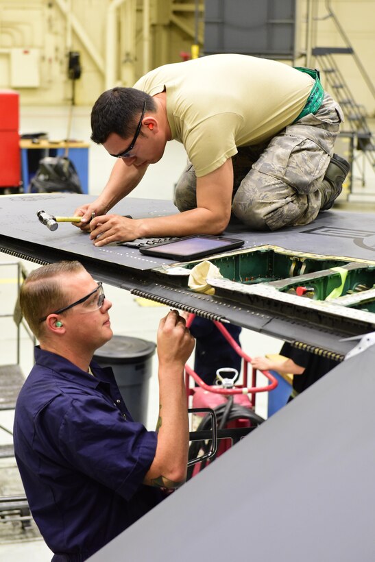 Tech. Sgt. Kevin Galdamez, 414th Maintenance Squadron sheet metal technician, removes stuck fasteners while Staff Sgt. Matthew O'Neal, 366th Equipment Maintenance Squadron sheet metal technician, prepares to replace an aileron surface at Mountain Home Air Force Base, Idaho June 1. Galdamez, temporarily assigned to the 366th Equipment Maintenance Squadron, is one of 10 reservists from Seymour Johnson Air Force Base, N.C., serving in an active duty capacity with the 366th Maintenance Group. (U.S. Air Force photo Staff Sgt. Lausanne Kinder)
