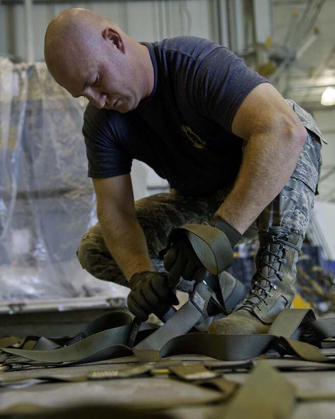 U.S. Air Force Tech. Sgt. Kevin Brown, 67th Aerial Port Squadron Port Dawg Challenge participant, untangles a net used to secure cargo during the pallet build up challenge at Dobbins Air Reserve Base, Ga., June 17, 2015. The Port Dawg Challenge was created to enhance and maintain the camaraderie, esprit de corps and prestige of aerial port Airmen while promoting professionalism, leadership, training and communication between "Port Dawgs." (U.S. Air Force photo by Senior Airman Josh Slavin/Released)