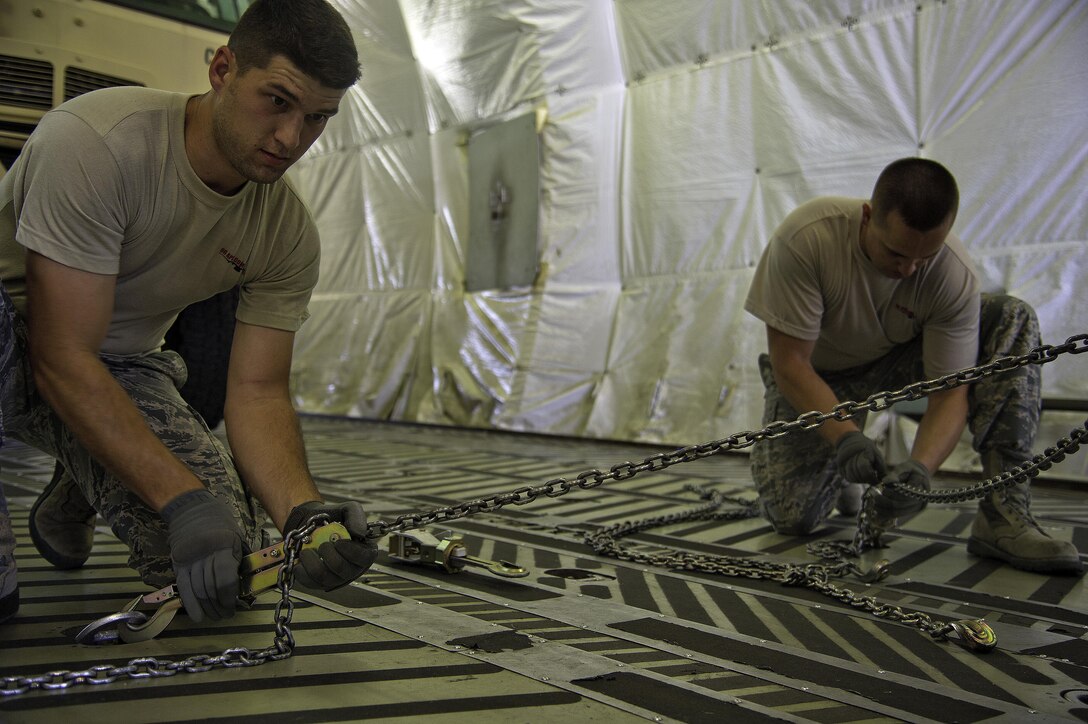 U.S. Air Force Staff Sgt. Andrew Hester (left) and Master Sgt. Mark Compton (right), 96th Aerial Port Squadron Port Dawg Challenge participants, tighten the cargo hold chains while completing the cargo restraint challenge at Dobbins Air Reserve Base, Ga., June 17, 2015. The Port Dawg Challenge was created to enhance and maintain the camaraderie, esprit de corps and prestige of aerial port Airmen while promoting professionalism, leadership, training and communication between "Port Dawgs." (U.S. Air Force photo by Senior Airman Josh Slavin/Released)