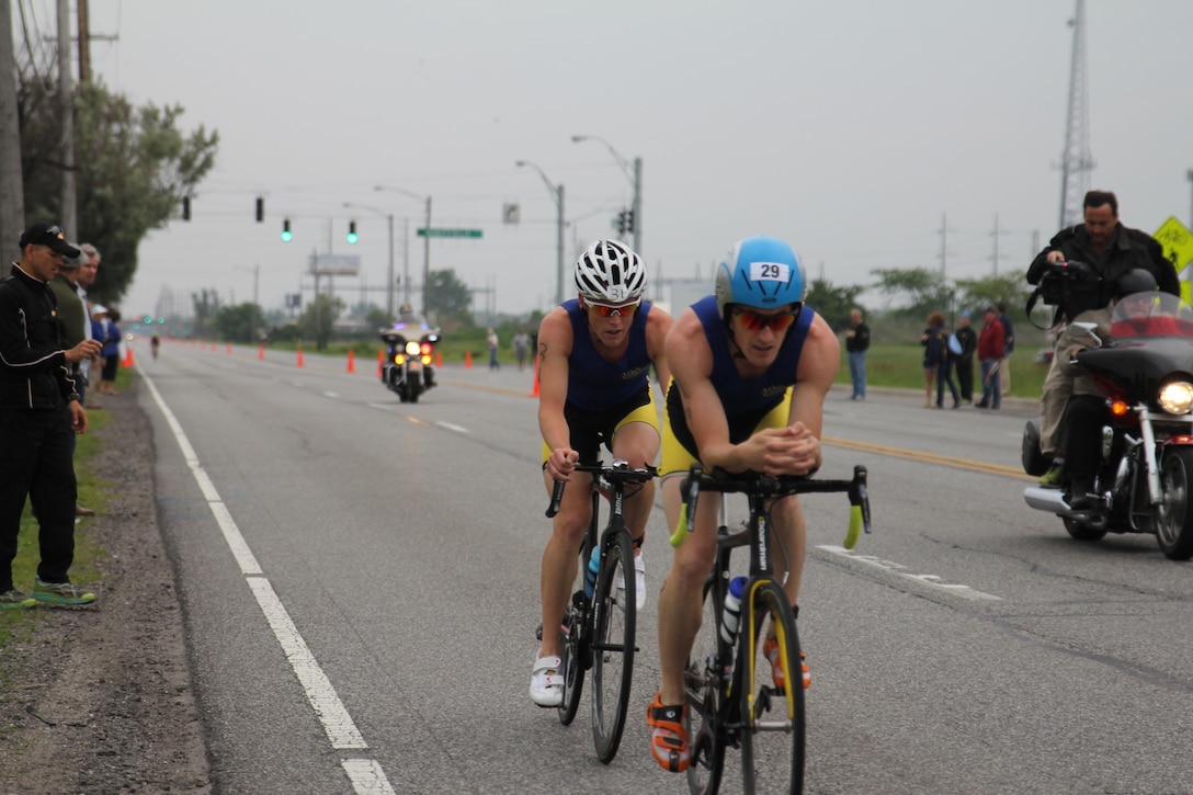 Navy Lieutenans Derek Oskutis (front) of NB San Diego, Calif. and 2015 Armed Forces Triathlon Champion Kyle Hooker of NAS Whidbey Island, Wash. take a commanding lead in the road race portion of the 2015 Armed Forces Triathlon Championship at Wolf Lake in Hammond, Ind. held in conjunction with Leon's Triathlon on June 7, 2015.