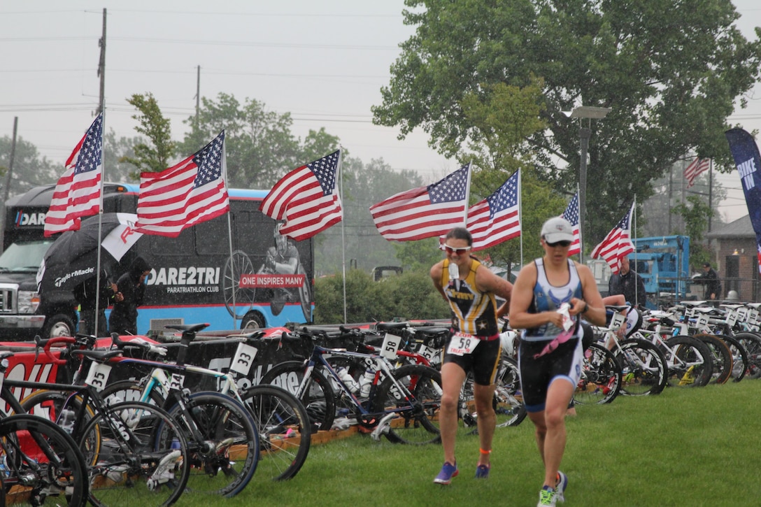 Armed Forces Women’s Triathlon Champion Army 2nd lt. Samone Franzese of Fort Sam Houston, Texas (left) along with Air Force Capt. Stephanie Mitchell of Fort Meade, Md. Begin the transition from cycle to run during the 2015 Armed Forces Triathlon Championship at Wolf Lake in Hammond, Ind. held in conjunction with Leon's Triathlon on June 7, 2015. Both athletes were selected to represent the United States Armed Forces during the upcoming Conseil International du Sport Militaire (CISM) 6th Military World Games in Mungyeong, South Korea 1-11 October 2015.