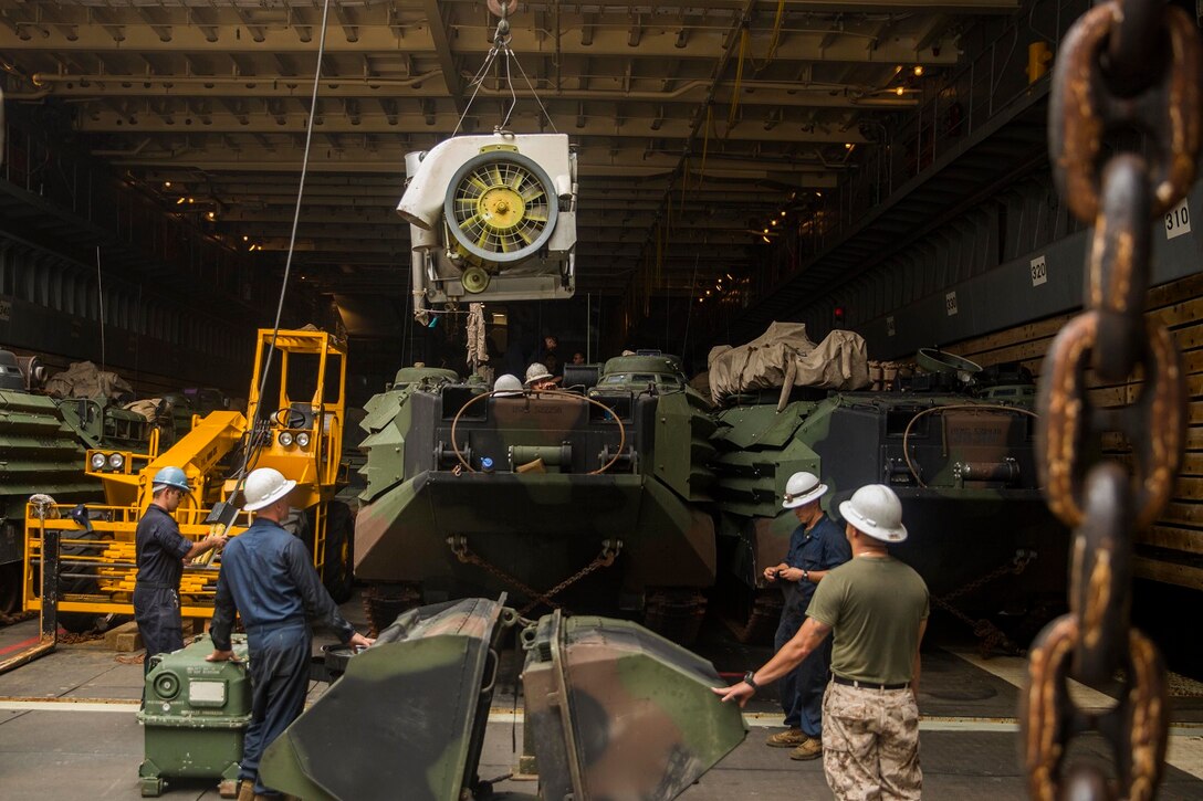 U.S. Marines with Kilo Company, Battalion Landing Team 3rd Battalion, 1st Marine Regiment, 15th Marine Expeditionary Unit, remove the coolant tower from an AAV-7 Amphibious Assault Vehicle during vehicle maintenance aboard USS Rushmore (LSD 47) at sea in the Strait of Malacca, June 15, 2015. AAV crewmen were replacing the hydrostatic steering unit, a component that controls the vehicle’s steering. (U.S. Marine Corps photo by Sgt. Emmanuel Ramos/Released)