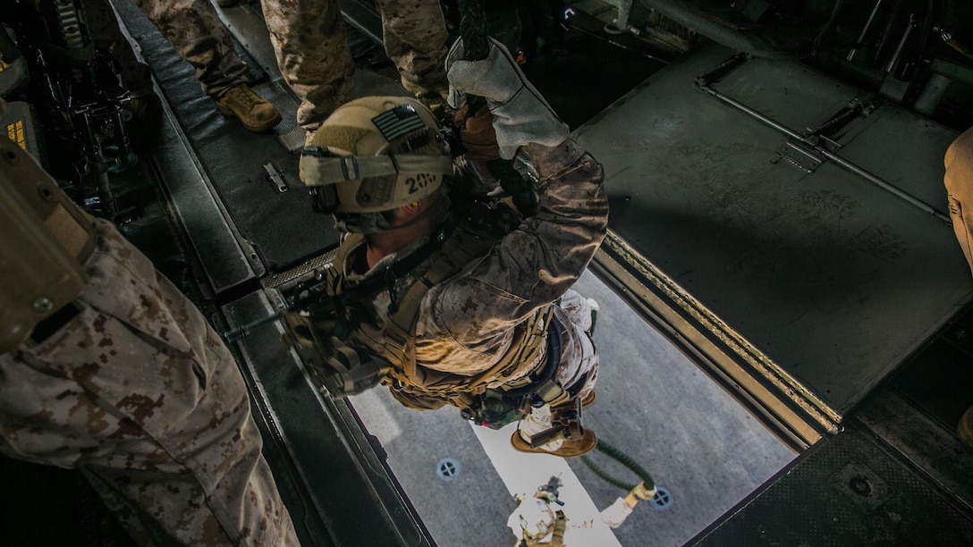A U.S. Marine with the 15th Marine Expeditionary Unit’s Maritime Raid Force fast-ropes out of a CH-53E Super Stallion onto the flight deck of the USS Essex (LHD 2) at sea in the Indian Ocean, June 17, 2015. Fast-roping gives these Marines the capability of a rapid insert from different types of aircraft onto both land and moving vessels. 