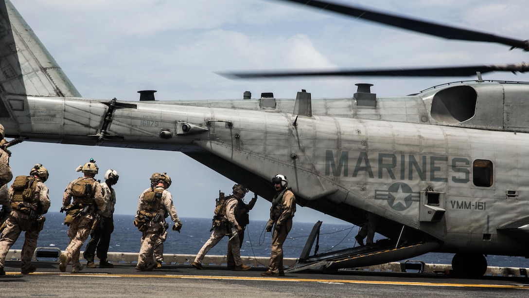 U.S. Marines with the 15th Marine Expeditionary Unit’s Maritime Raid Force load into a CH-53E Super Stallion aboard the USS Essex (LHD 2) at sea in the Indian Ocean, June 17, 2015. These Marines were practicing fast-roping out of the helicopter onto a moving vessel; an essential skill for the MRF during visit, board, search, and seizure missions. 