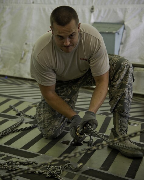 U.S. Air Force Master Sgt. Mark Compton, 96th Aerial Port Squadron Port Dawg Challenge participant, tightens a cargo hold chain while completing the cargo restraint challenge at Dobbins Air Reserve Base, Ga., June 17, 2015. The Port Dawg Challenge was created to enhance and maintain the camaraderie, esprit de corps and prestige of aerial port Airmen while promoting professionalism, leadership, training and communication between "Port Dawgs." (U.S. Air Force photo by Senior Airman Josh Slavin/Released)