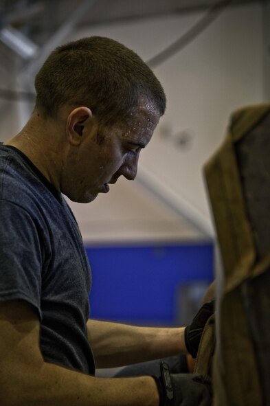 U.S. Air Force Staff Sgt. Jonathan Parrish, 67th Aerial Port Squadron Port Dawg Challenge participant, secures a cargo load during the pallet build up challenge at Dobbins Air Reserve Base, Ga., June 17, 2015. The Port Dawg Challenge was created to enhance and maintain the camaraderie, esprit de corps and prestige of aerial port Airmen while promoting professionalism, leadership, training and communication between "Port Dawgs." (U.S. Air Force photo by Senior Airman Josh Slavin/Released)