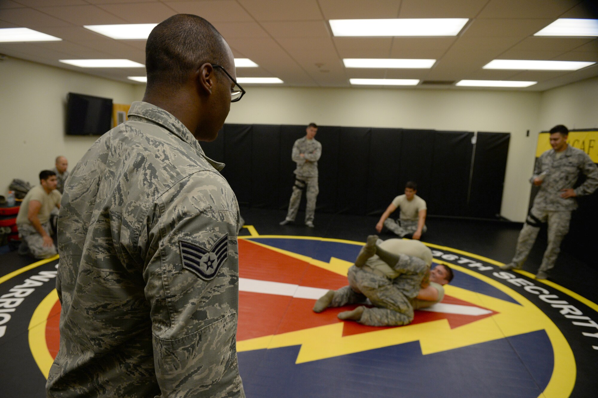Staff Sgt. Felix Simon, 736th Security Forces Squadron Commando Warrior instructor, left, observes Airmen during a timed hand-to-hand combat exercise June 13, 2015, in the Pacific Regional Training Center at Northwest Field, Guam. Simon instructs security forces Airmen in essential combatives and tactical field skills. (U.S. Air Force photo by Senior Airman Alexander W. Riedel/Released)