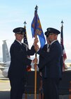 Col. Randy Huiss, 15th Wing commander, passes the 15th Operation Group guidon to Col. Charles Velino, 15th Operations Group In-coming commander, during the 15th Operations Group change of command ceremony on Joint Base Pearl Harbor-Hickam, Hawaii, June 18, 2015. As the new 15th OG commander, Velino is charged with ensuring the combat readiness of more than 300 personnel assigned to five operational squadrons. (U.S. Air Force Photo by Tech Sgt. Terri Paden/Released)
