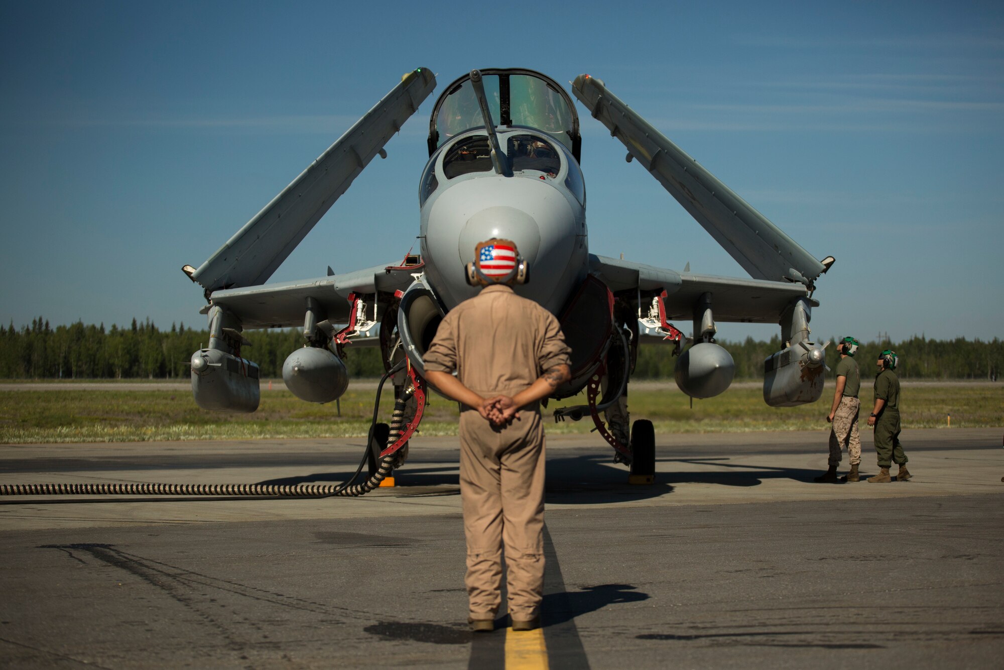 Lance Cpl. Jonathan L. Vega, from Miami, Florida, stands in front of an EA-6B Prowler while other Marines inspect the aircraft during Exercise Northern Edge 2015 June 15 at Eielson Air Force Base, Alaska. The Prowler is an electronic warfare aircraft used to jam radar signals making other military aircraft invisible to radar. NE15 is Alaska’s premier joint training exercise designed to practice operations, techniques and procedures as well as enhance interoperability among the services. Thousands of participants from all of the services, airmen, soldiers, sailors Marines and Coast Guardsmen from active duty, reserve and National Guard Units are involved. Vega is an aircraft mechanic with Marine Tactical Electronic Warfare Squadron 2, Marine Aircraft Group 14, 2nd Marine Aircraft Wing, II Marine Expeditionary Force. (U.S. Marine Corps Photo by Cpl. Thor J. Larson/Released)