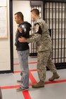 Staff Sgt. Jaime Gutierrez, 341st Security Forces Support Squadron trainer (left), simulates an inmate during in-processing as Tech. Sgt. Earl Bagwell, 341st Security Forces Squadron, NCOIC of investigations, pats him down at Malmstrom Air Force Base’s confinement center. Reoccurring training sessions for confinement supervisors provide the skills necessary for them to complete their mission safely and efficiently. (Courtesy photo)