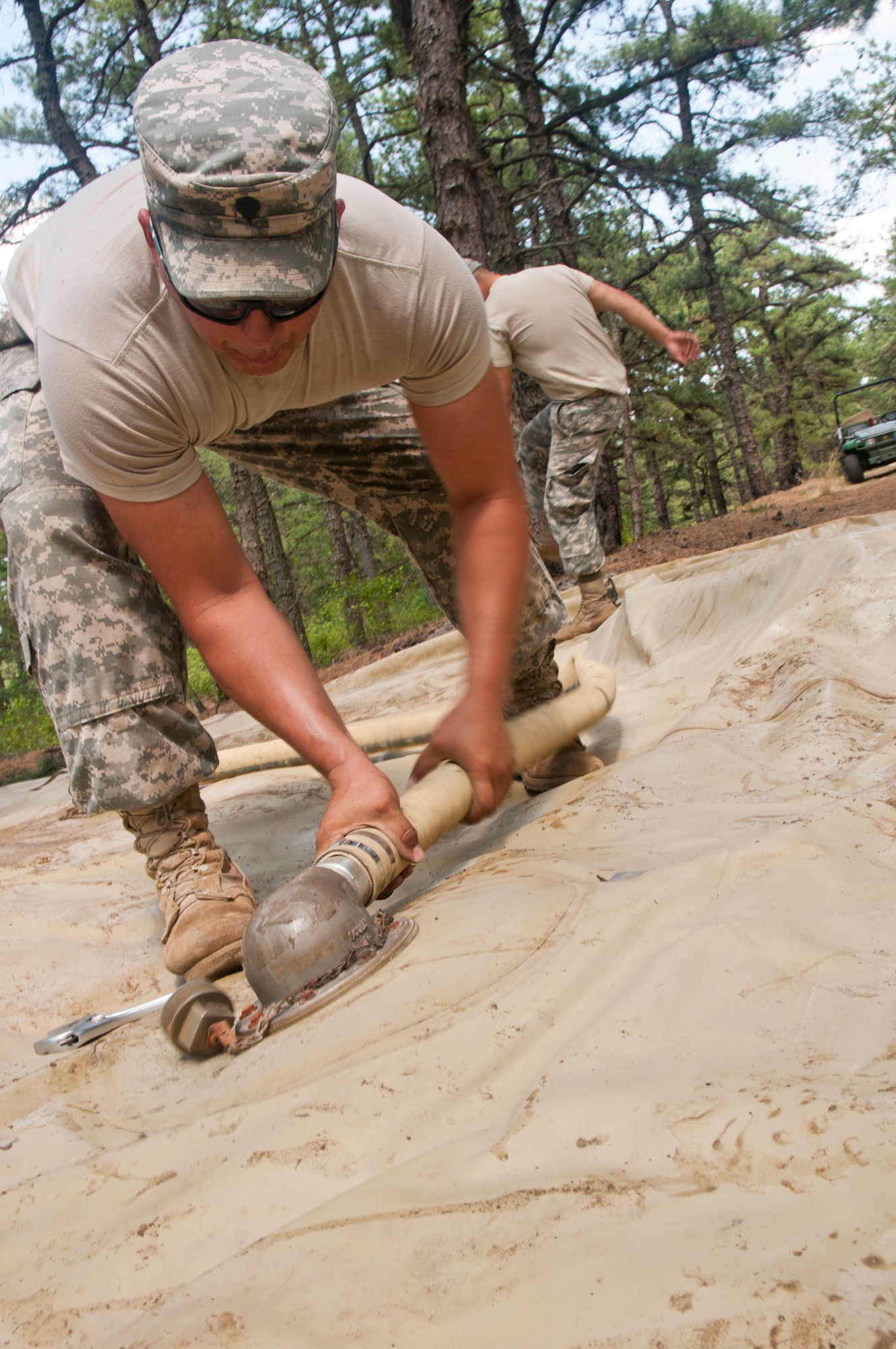 Army Reserve water purification Spc. Rafael Gonzalez, from the 971st Quartermaster Detachment out of Rio Grande, Texas, connects the hose to the 20,000-gallon water bag that will hold potable water as part of the Quartermaster Liquid Logistic Exercise (QLLEX) portion of the Combat Sustainment Training Exercise (CSTX) Global Lightning 2015 at Joint Base McGuire-Dix-Lakehurst, June 10, 2015.