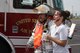 Senior firefighter, Michael Leedom, escorted simulated crash victim, Jodi Fales away from a simulated aircraft accident site during a Major Accident Response Exercise held at Joe Foss Field, S.D. June 18, 2015.  Leedom served as the acting operations section chief during the exercise which involved members of the National Guard, local law enforcement, firefighters, emergency medical technicians and the airport authority.  Fales is a student from the University of Sioux Falls and volunteered to participate in the exercise.(National Guard photo by Tech. Sgt. Christopher Stewart/Released)