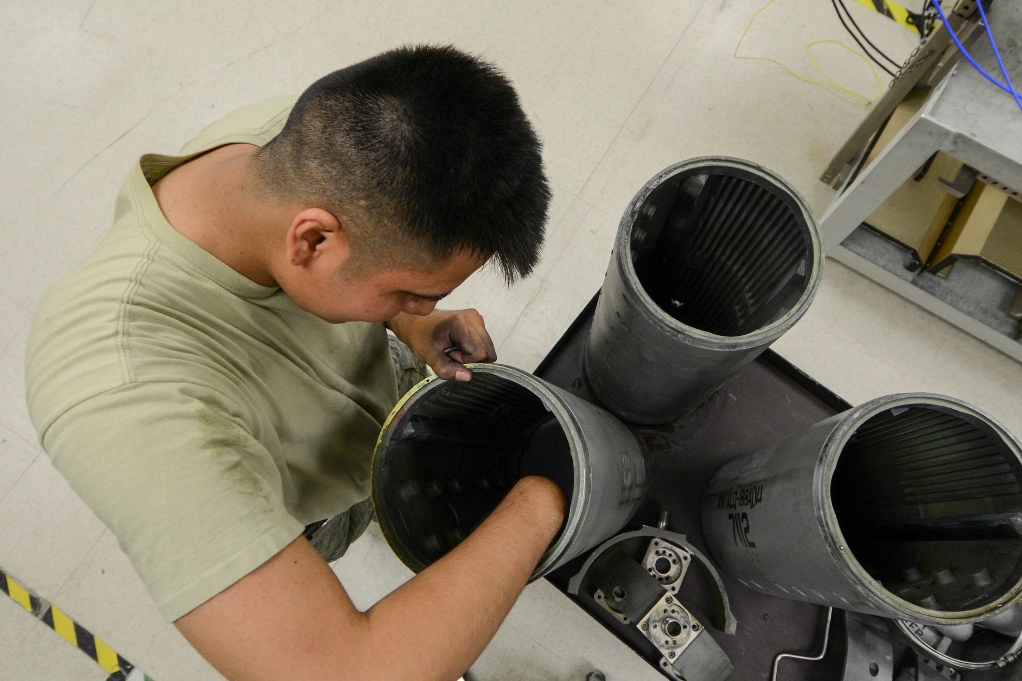 U.S. Air Force Airman 1st Class Anthony Davis, a 354th Maintenance Squadron electronic warfare technician, removes tray clamps from an electronic attack pod May 26, 2015, at Eielson Air Force Base, Alaska. Each pod is completely disassembled to ensure there is no E36 deicer intrusion. (U.S. Air Force photo by Senior Airman Ashley Nicole Taylor/Released)
