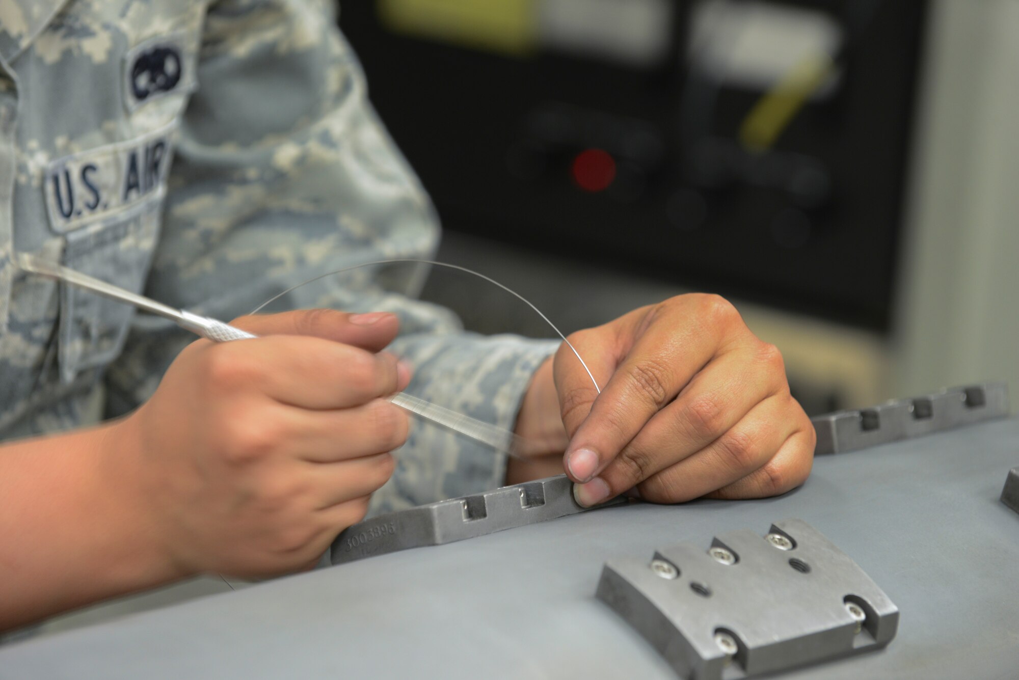 U.S. Air Force Senior Airman Elizabeth Looper, a 354th Maintenance Squadron electronic warfare technician, replaces safety wire on an electronic attack pod May 26, 2015, at Eielson Air Force Base, Alaska. The pods provide an offensive electronic attack that degrades an enemy aircraft's radar. (U.S. Air Force photo by Senior Airman Ashley Nicole Taylor/Released)
