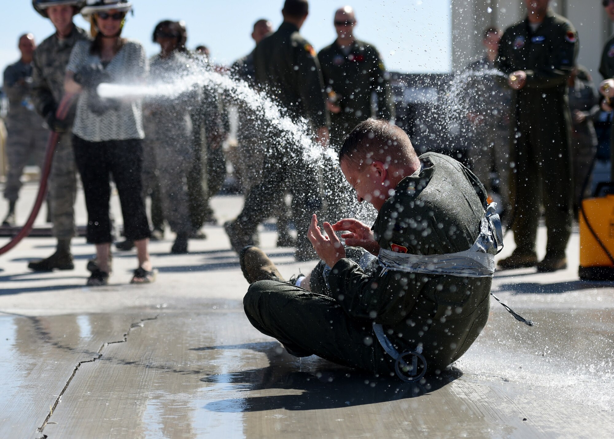 Col. James Cluff, 432nd Wing/432nd Air Expeditionary Wing commander, gets sprayed by his wife and fellow Airmen following his fini flight May 28th, 2015 on Creech Air Force Base Nevada. The fini-flight celebration has evolved over the years and now includes a toast and dowsing with water for the aircraft and aircrew. (U.S. Air Force photo by Tech. Sgt. Nadine Barclay/RELEASED)