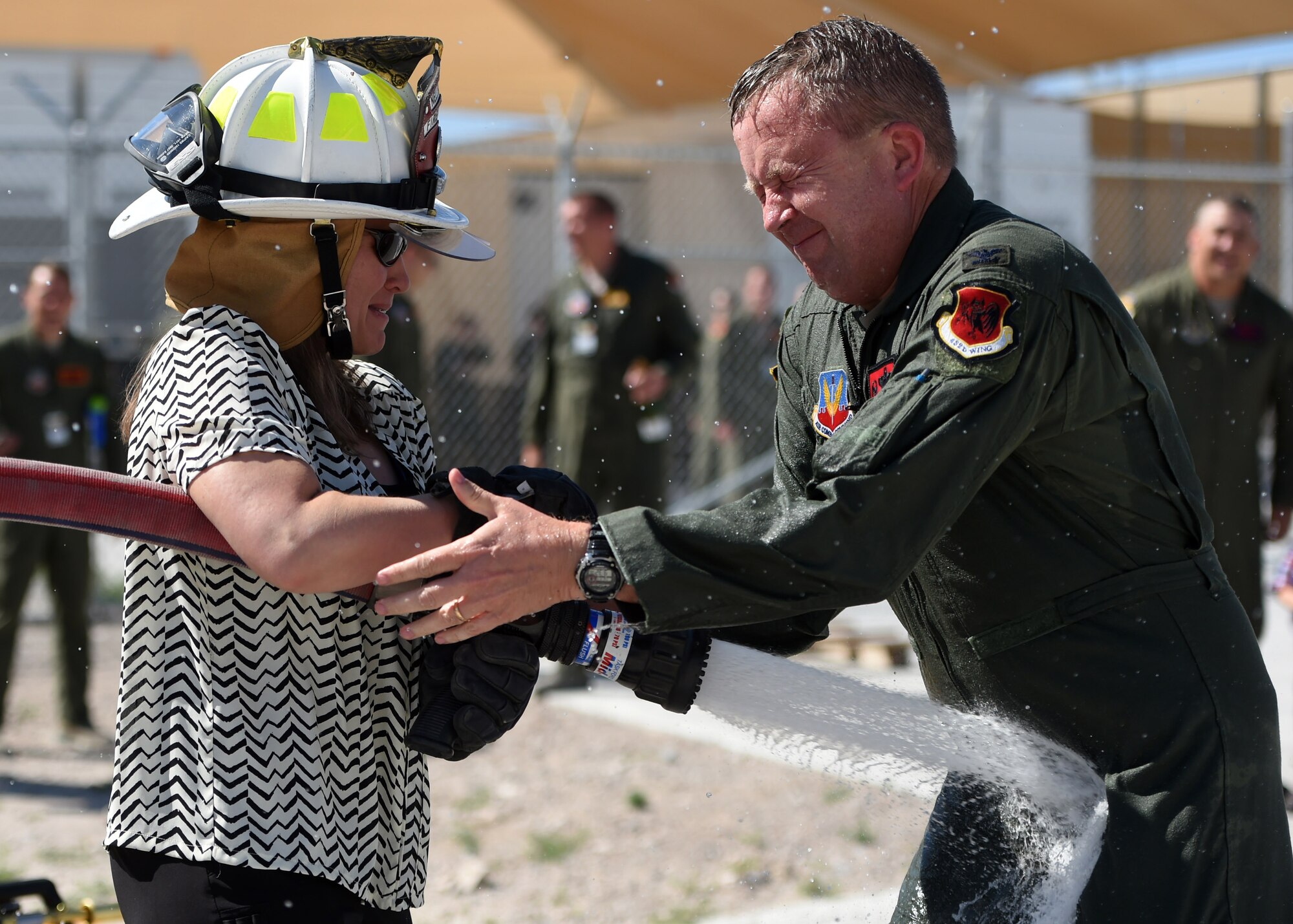 Col. James Cluff, 432nd Wing/432nd Air Expeditionary Wing commander, gets sprayed by his wife and fellow Airmen following his fini flight May 28th, 2015 on Creech Air Force Base Nevada. The fini-flight celebration has evolved over the years and now includes a toast and dowsing with water for the aircraft and aircrew. (U.S. Air Force photo by Tech. Sgt. Nadine Barclay/RELEASED)