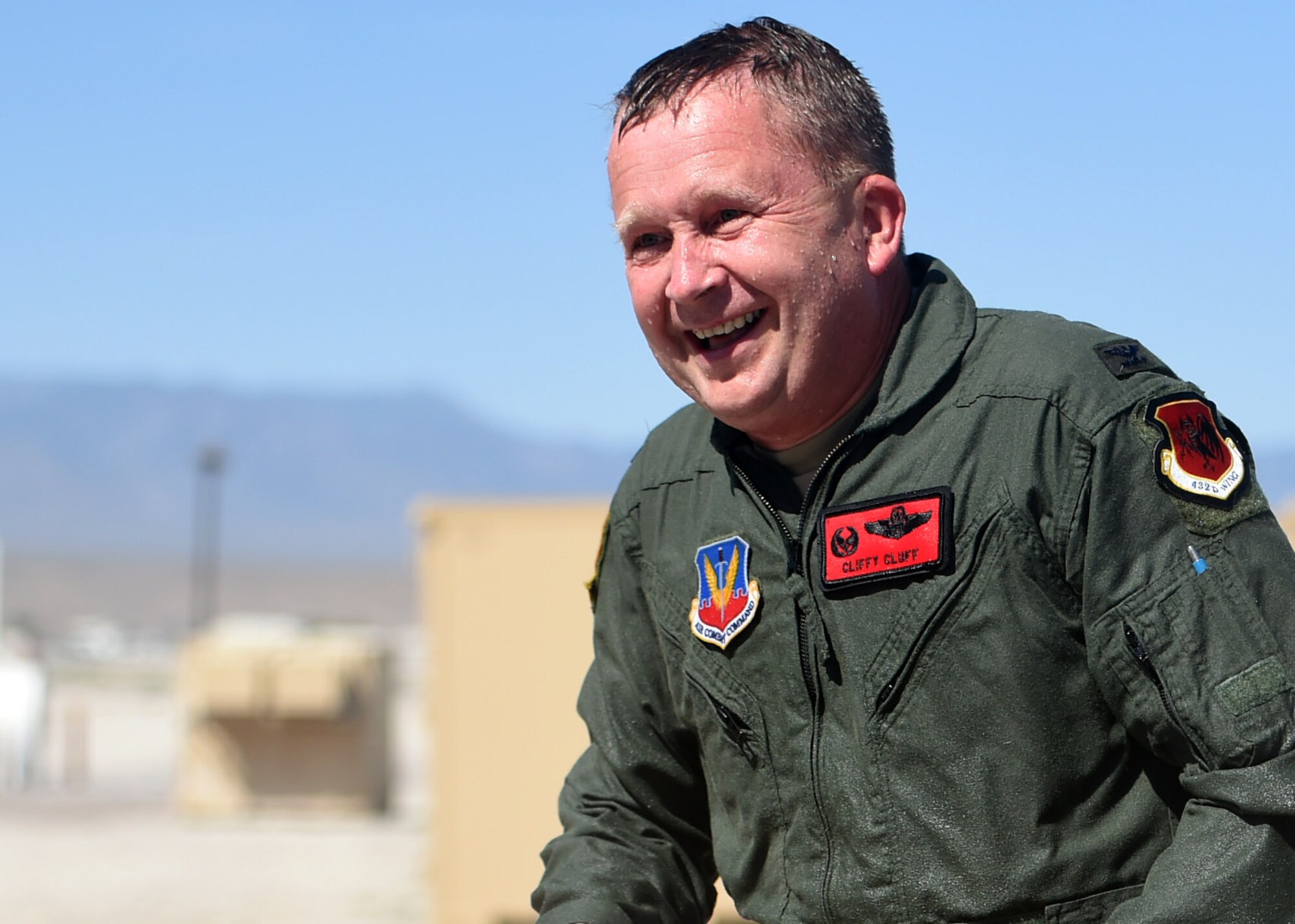 Col. James Cluff, 432nd Wing/432nd Air Expeditionary Wing commander, laughs after being hosed down by Team Creech members following his final flight with the wing May 28th, 2015 on Creech Air Force Base Nevada. The wing passed the 2 million flying hour milestone Oct. 22, 2013 under Col. Cluff’s command. (U.S. Air Force photo by Tech. Sgt. Nadine Barclay/RELEASED)