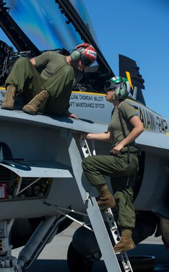 U.S. Marine Corps Lance Cpl. Andrea Shimooka, right, a communication and navigation technician with Marine All-Weather Fighter Attack Squadron (VMFA [AW]) 242, 1st Marine Aircraft Wing has a discussion with Sgt. Jospeh Channell, an aviation ordnance technician with VMFA (AW)-242, while conducting routine maintenance on a Marine Corps FA-18D Hornet assigned to VMFA (AW)-242 during Exercise Northern Edge 15 at Eielson Air Force Base, Alaska, June 15, 2015. Northern Edge is Alaska’s premier joint training exercise designed to practice operations, techniques and procedures as well as enhance interoperability among the services. Thousands of participants from all services, Airmen, Soldiers, Sailors, Marines and Coast Guardsmen from active duty, Reserve and National Guard units are involved. (U.S. Marine Corps photo by Cpl. Suzanne Dickson/Released)