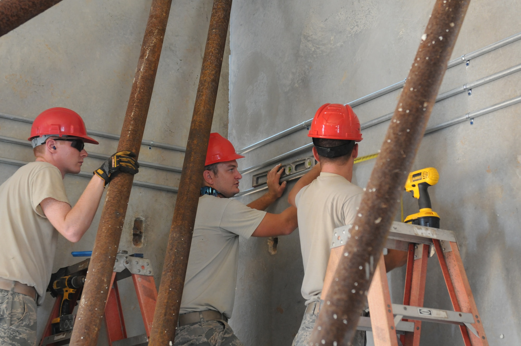 Airmen from the Virginia Air National Guard’s Virginia Beach-based 203rd RED HORSE Squadron and the 202nd RHS from Camp Blanding, Florida refine and train upon essential skills June 5, 2015 during a joint training mission to erect a Facilities Systems Training facility at Anderson Air Force Base, Guam. The Airmen are conducting training while building the FST facility under the Air National Guard’s Deployment for Training program. This training mission presents the opportunity for the RED HORSE squadron Airmen to focus on: project planning, design, surveying, site development with cut and fill operations, heavy equipment operations, vehicle maintenance and repair, project and troop management, logistical and personnel support, food preparation and lodging procedures, utility systems, and electrical and fire alarm installation. (U.S. Air National Guard photo by Tech. Sgt. Meghan Skrepenski/Released)