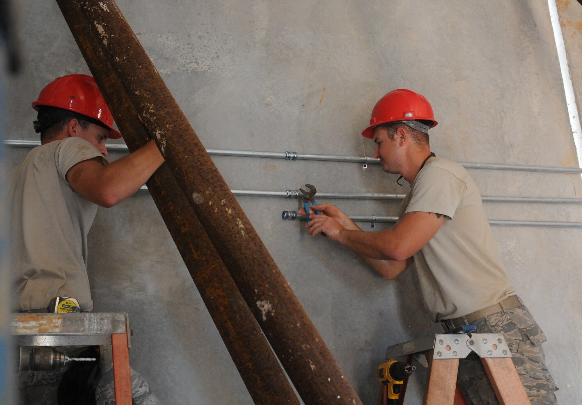 Airmen from the Virginia Air National Guard’s Virginia Beach-based 203rd RED HORSE Squadron and the 202nd RHS from Camp Blanding, Florida refine and train upon essential skills June 5, 2015 during a joint training mission to erect a Facilities Systems Training facility at Anderson Air Force Base, Guam. The Airmen are conducting training while building the FST facility under the Air National Guard’s Deployment for Training program. This training mission presents the opportunity for the RED HORSE squadron Airmen to focus on: project planning, design, surveying, site development with cut and fill operations, heavy equipment operations, vehicle maintenance and repair, project and troop management, logistical and personnel support, food preparation and lodging procedures, utility systems, and electrical and fire alarm installation. (U.S. Air National Guard photo by Tech. Sgt. Meghan Skrepenski/Released)