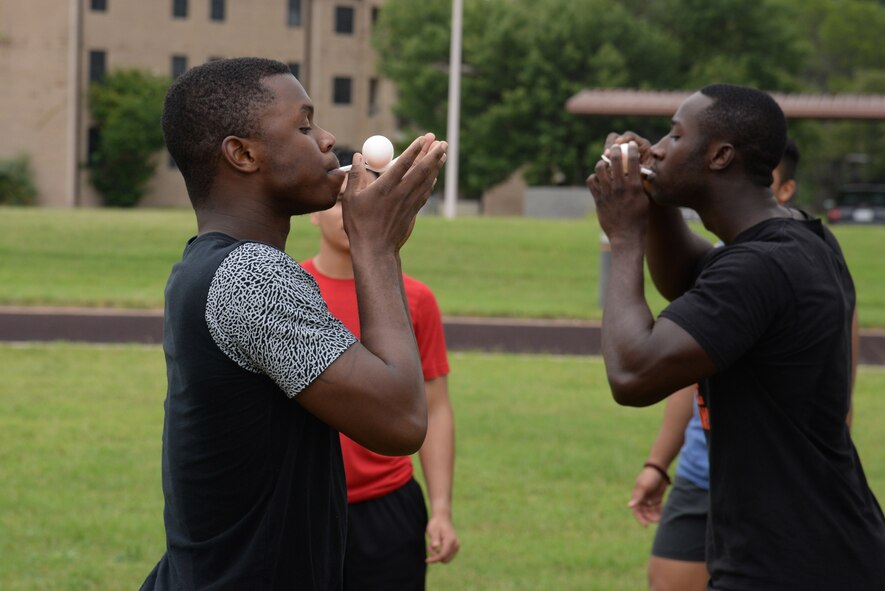 Airman 1st Class Tyler Walker, left, 47th Civil Engineer Squadron firefighter apprentice, competes against Senior Airman DiJohn Lester, right, Medical Operations Squadron bioenvironmental engineering technician, in an egg balancing race on Laughlin Air Force Base, Texas, June 13, 2015. Laughlin dorm residents formed teams to compete in various events in attempt to take home first place and win prizes. (U.S. Air Force photo by Airman 1st Class Brandon May)