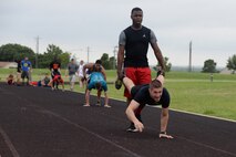 Airman 1st Class Tyler Walker, 47th Civil Engineer Squadron firefighter apprentice, holds the legs of Senior Airman Eric Carey, 47th Security Forces Squadron patrolman, as they compete in a 100 meter wheelbarrow race at the track on Laughlin Air Force Base, Texas, June 13, 2015. This was one of many events that were part of Laughlin’s first ever Dorm Olympics, where Senior Airman and below formed teams of four to see who would be declared the winner. (U.S. Air Force photo by Airman 1st Class Brandon May)