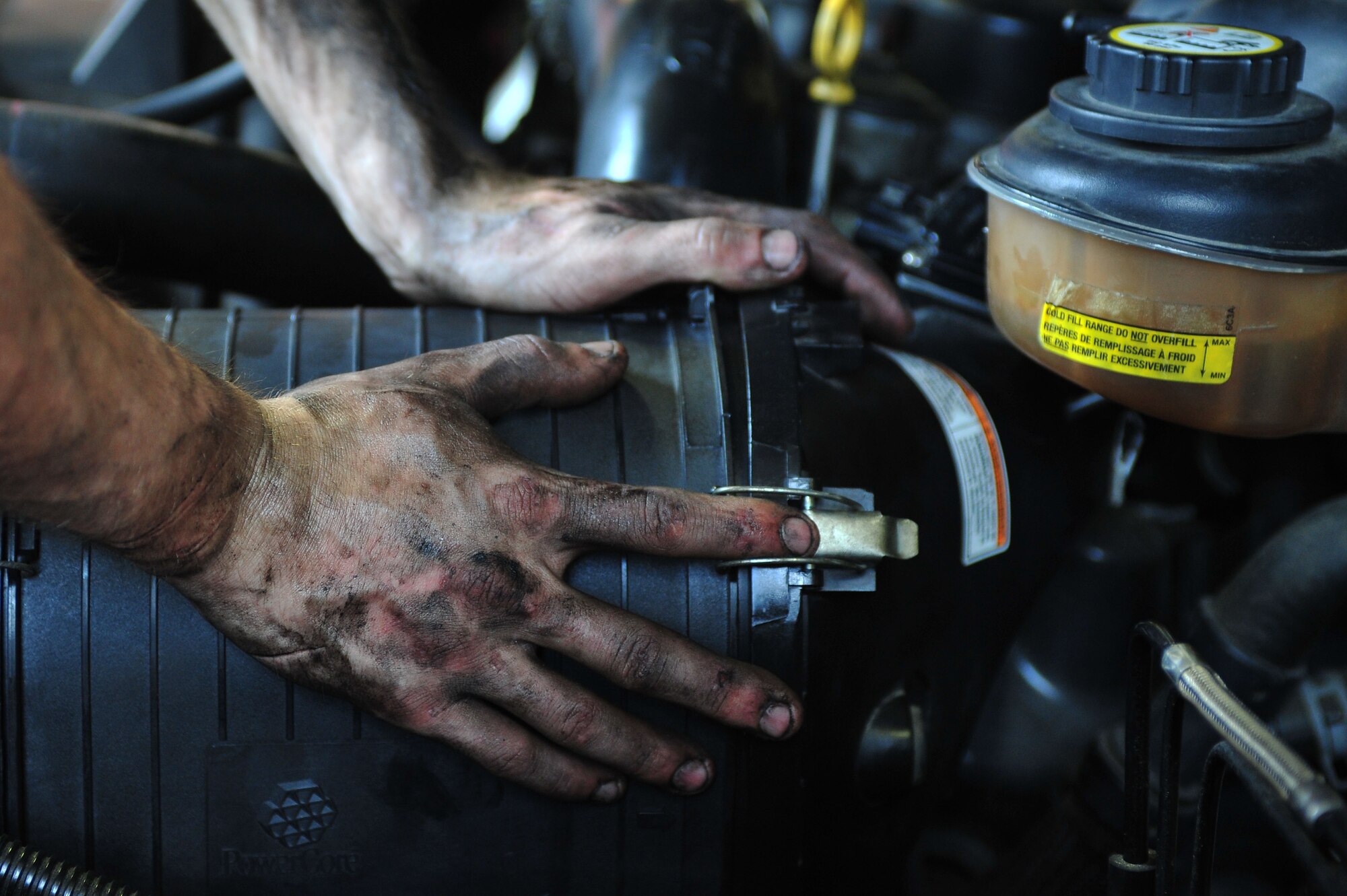 Senior Airman Chris Morel, 4th Logistics Readiness Squadron vehicle maintenance technician, secures an air filter inside a government vehicle, June 11, 2015, at Seymour Johnson Air Force Base, North Carolina. An air filter removes malicious substances such as dust, pollen mold and bacteria from the air in an engine. (U.S. Air Force photo/Senior Airman John Nieves Camacho)