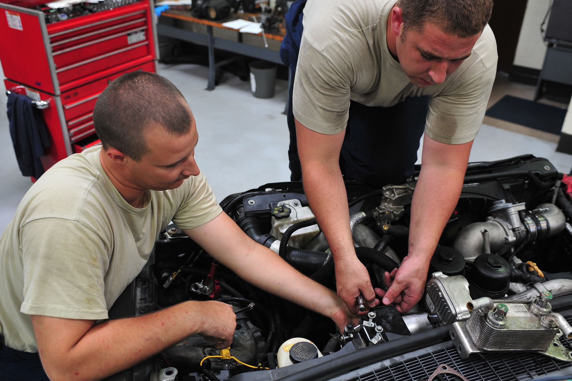 Senior Airman Charles Norris (left), 4th Logistics Readiness Squadron vehicle maintenance technician, and Staff Sgt. Kenneth Brown, 4th LRS vehicle maintenance floor supervisor, install a turbocharger in a Ford F-350 Bobtail truck, June 11, 2015, at Seymour Johnson Air Force Base, North Carolina. Vehicle maintainers are specialists who inspect, troubleshoot and repair vehicles used in direct support of Air Force missions. (U.S. Air Force photo/Senior Airman John Nieves Camacho) 
