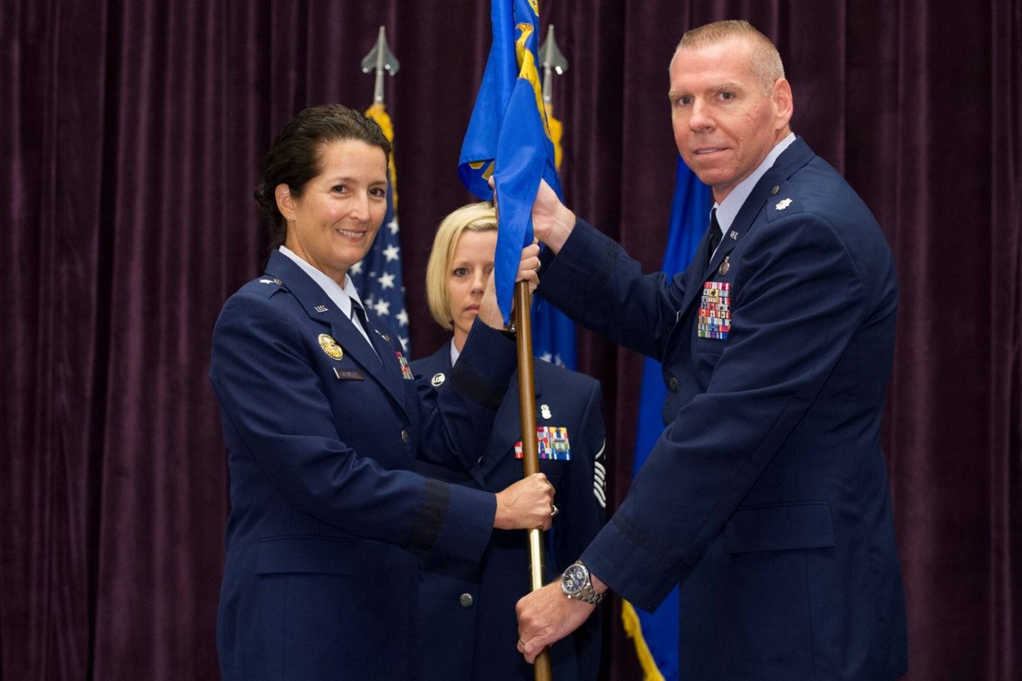 Brig. Gen. Nina Armagno, 45th Space Wing commander, presents Lt. Col. Steven Clark, 45th Comptroller Squadron commander, with the 45th CPTS guidon during a change of command ceremony June 15, 201, at Patrick Air Force Base, Fla. Changes of command are a military tradition representing the transfer of responsibilities from the presiding officials to the upcoming official. (U.S. Air Force photo/Cory Long) (Released) 