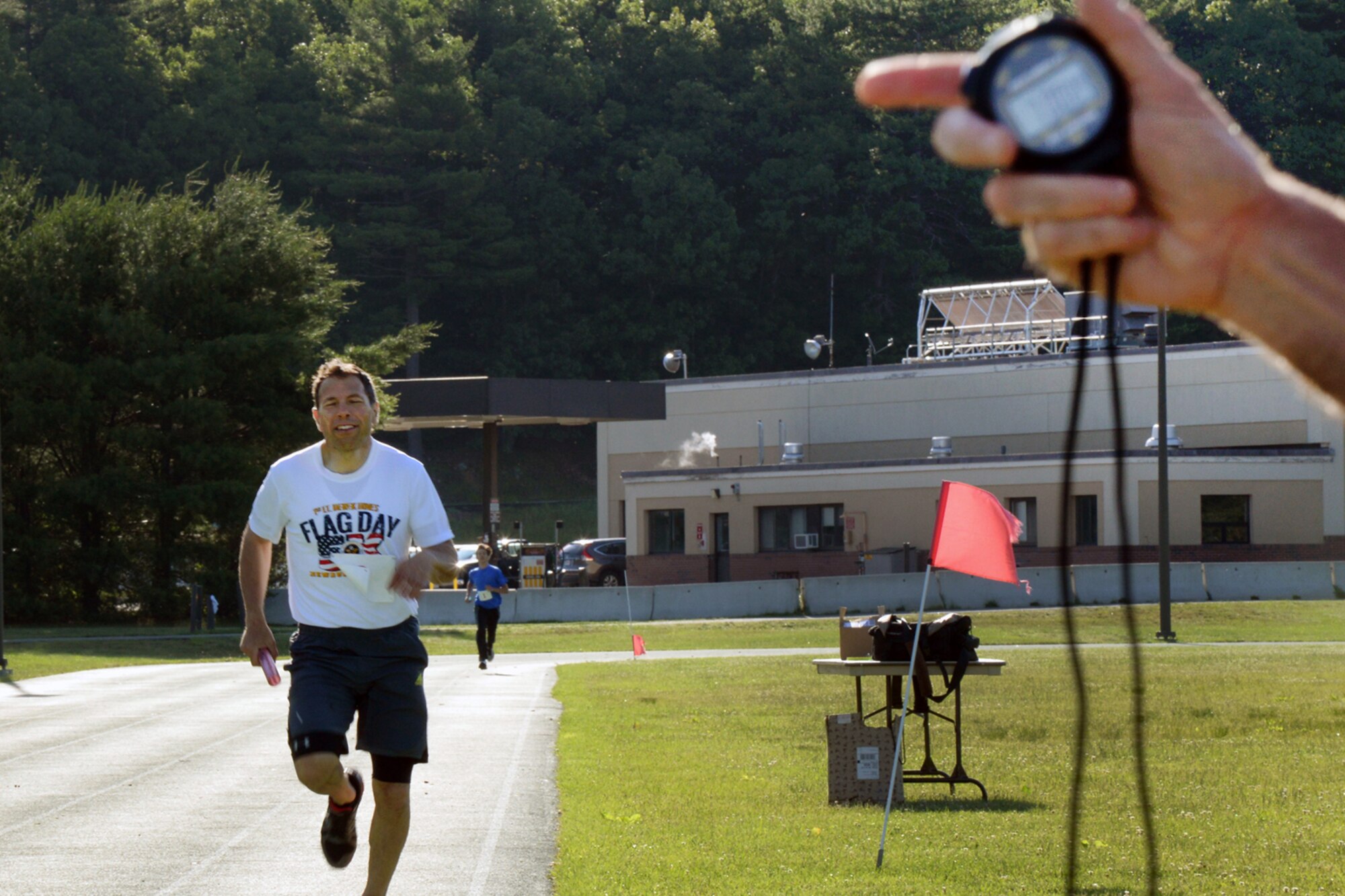 Gerald Cavallo, a Battle Management Directorate program manager, completes his leg of a relay race at the base track during the Summer Thunder Relays June 17. Top finishers for both events were Blueberry and the Fruits for the 3x800 with a winning time of 7 minutes 19 seconds and for the 4x100 with a winning time of 53.7 seconds..  (U.S. Air Force photo by Linda LaBonte Britt)