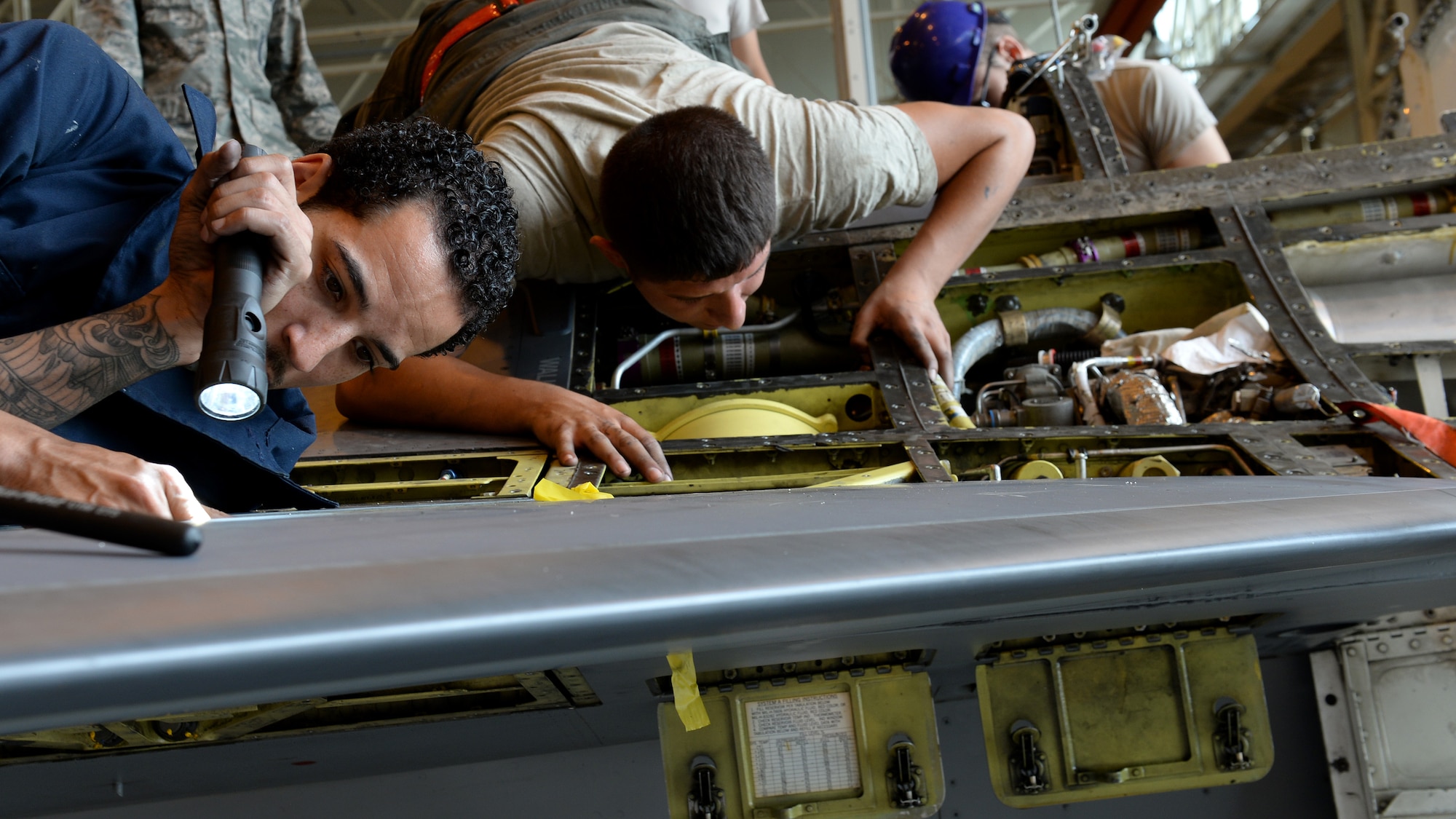 U.S. Air Force Airmen 1st Class Nathaniel Lott and Juanluis Cota, 31st Aircraft Maintenance Squadron phase technicians, search for gigs during a phase inspection of an F-16 Fighting Falcon, June 15, 2015, at Aviano Air Base, Italy. Gigs are minor discrepancies that may occur during flight as force is exerted on the aircraft. (U.S. Air Force Airman 1st Class Cary Smith/Released)